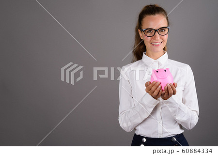 Young beautiful businesswoman against gray background 60884334