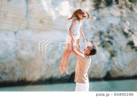 Little girl and happy dad having fun during beach vacation Little girl and happy dad having fun during beach vacation 60890286