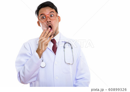 Studio shot of young Asian man doctor wearing eyeglasses looking 60899326