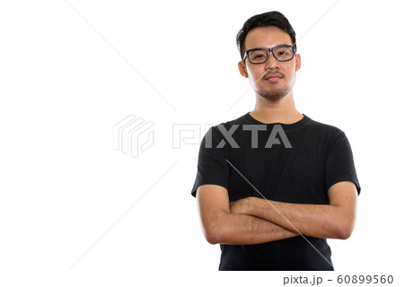 Studio shot of young Asian man wearing eyeglasses with arms cros 60899560