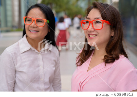 Two mature Asian women together outside the mall in Bangkok city Two mature Asian women together outside the mall in Bangkok city 60899912