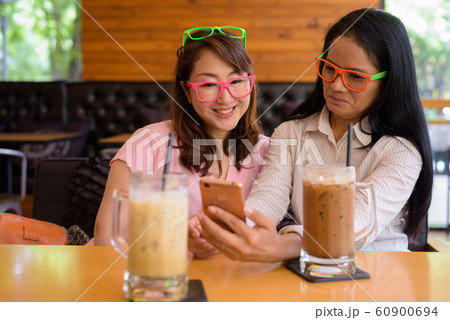 Two mature Asian women together hanging out at the coffee shop 60900694