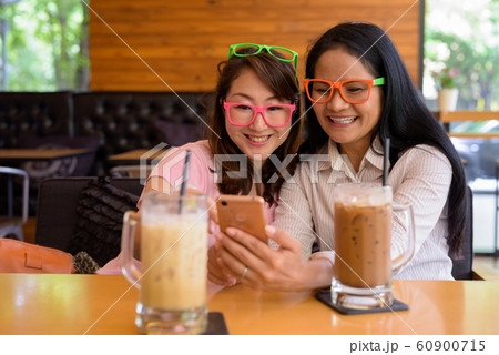 Two mature Asian women together hanging out at the coffee shop 60900715