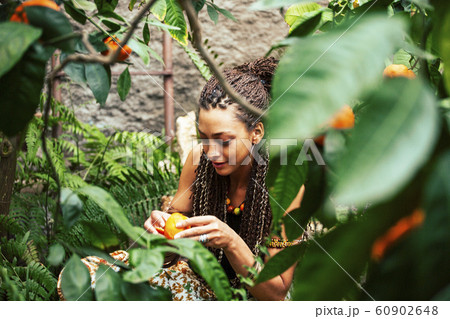 pretty islam woman in orange grove smiling, real muslim girl cheerful , nature organic people concept 60902648