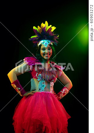 Beautiful young woman in carnival mask and masquerade costume in colorful lights 60903272