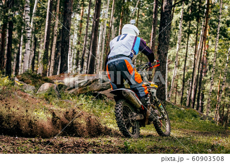 motocross rider riding forest trail 60903508