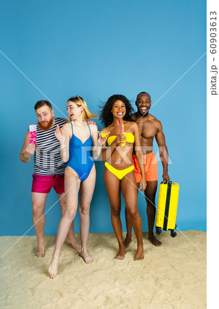 Happy young friends resting on blue studio background 60903613