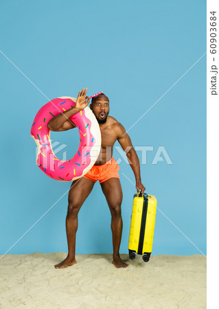 Happy young man resting on blue studio background Happy young man resting on blue studio background 60903684