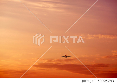 Airplane taking off and flying high in sunset sky 60905793