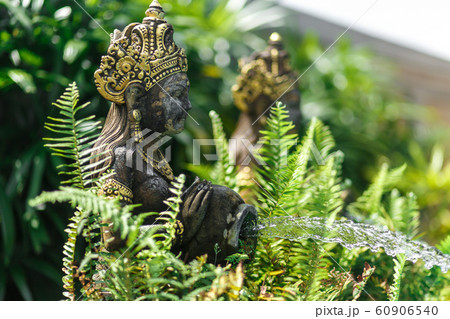 Balinese statuette of a girl with a pot from which 60906540