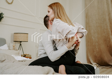Close-up portrait of a beautiful young couple hugs in bed at home 60908604