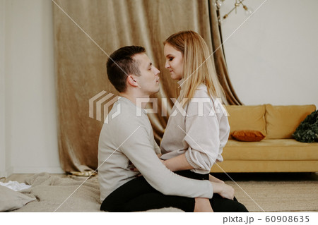 Close-up portrait of a beautiful young couple hugs in bed at home 60908635