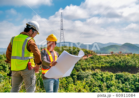 Two engineer man discuss together for the construction in far away land Two engineer man discuss together for the construction in far away land 60911084