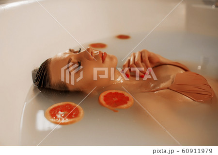 Sexy young woman with perfect skin in a bath with milk and circles of grapefruit Sexy young woman with perfect skin in a bath with milk and circles of grapefruit 60911979