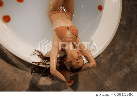 Sexy young woman with perfect body in a bath with milk and circles of grapefruit Sexy young woman with perfect body in a bath with milk and circles of grapefruit 60911980