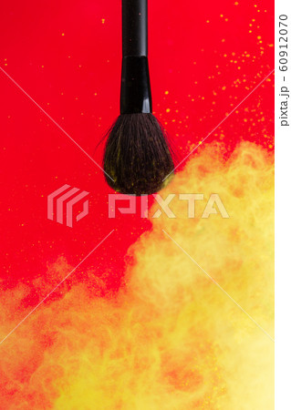 cosmetic brush and sprayed cloud of cosmetics on a red concept cosmetic brush and sprayed cloud of cosmetics on a red concept 60912070