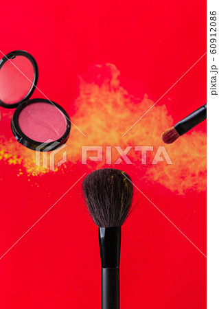 cosmetic brush and sprayed cloud of cosmetics on a red concept cosmetic brush and sprayed cloud of cosmetics on a red concept 60912086