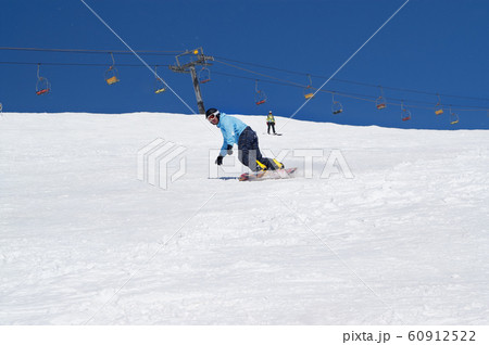 Snowboarder descends on snowy ski slope at winter 60912522