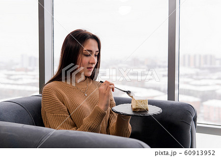 girl eating a cake while sitting in a chair in 60913952