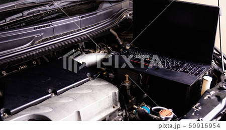 Laptop computer on car mechanic engine for service Laptop computer on car mechanic engine for service 60916954