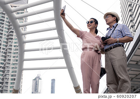 Senior Asian couple selfie by mobile outdoors. 60920207