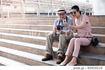 Senior Asian couples sit on the stairs while 60920210