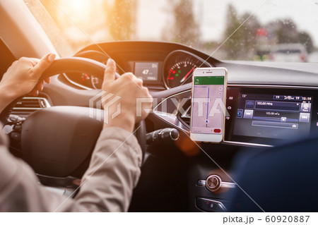 hands of a woman on a steering wheel of a car 60920887