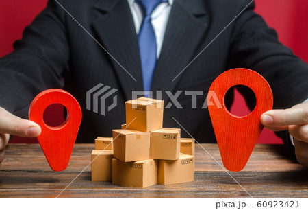 A businessman sets a destination for goods delivery. Global market and business, import and export. Trade in new markets. Distribution, freight transportation shipment. Logistics and warehousing. 60923421