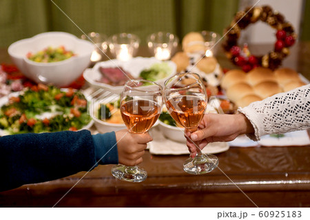 クリスマス料理が並んだ食卓で夕食の前に乾杯 クリスマス料理が並んだ食卓で夕食の前に乾杯 60925183