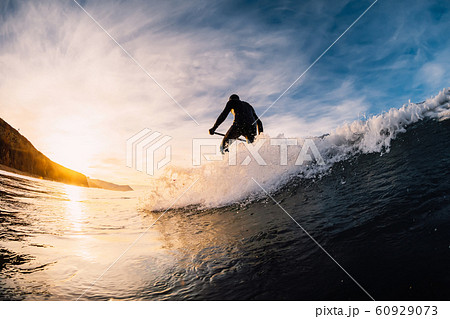 Stand Up Paddle surfing on waves. SUP board and surfer in wetsuit in morning Stand Up Paddle surfing on waves. SUP board and surfer in wetsuit in morning 60929073