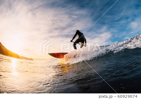 Stand Up Paddle surfing on waves. SUP board and surfer in wetsuit in morning 60929074