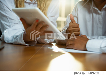 Close up of african-american human's hands using tablet on wooden table Close up of african-american human's hands using tablet on wooden table 60929188