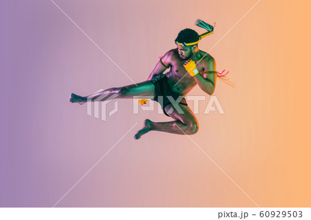 Muay thai. Young man exercising thai boxing on gradient background 60929503