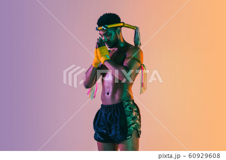 Muay thai. Young man exercising thai boxing on gradient background 60929608