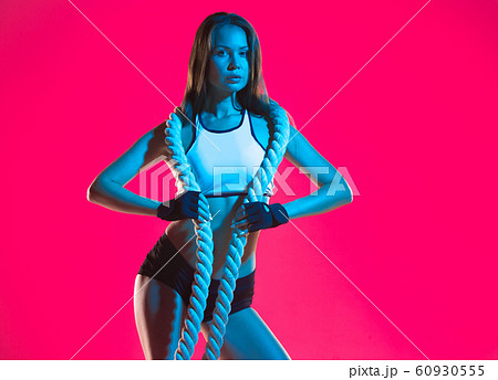 Muscular young female athlete on pink background Muscular young female athlete on pink background 60930555