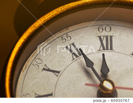 Golden vintage alarm clock showing five to twelve Golden vintage alarm clock showing five to twelve 60930767
