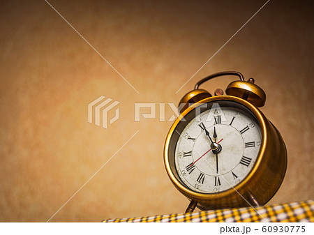 Golden vintage alarm clock showing five to twelve Golden vintage alarm clock showing five to twelve 60930775