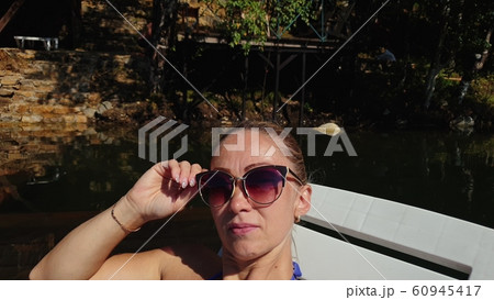 Woman shooting self portrait. Take photo and video on smartphone. Girl rest, relax, walk in sunglasses, make selfie. Blogger broadcast video vlogging. 60945417