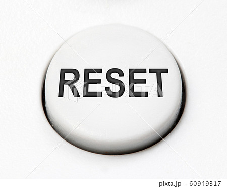 A white round button switch for reset close up. 60949317