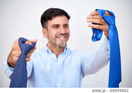 Smiling man choosing necktie Smiling man choosing necktie 60950662