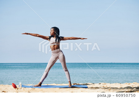 Young woman in warrior pose Young woman in warrior pose 60950750
