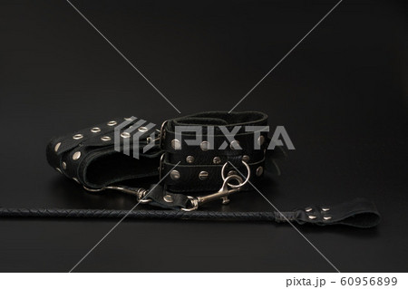 Leather handcuffs and stack for BDSM games on black background. Accessories for adult sexual game 60956899