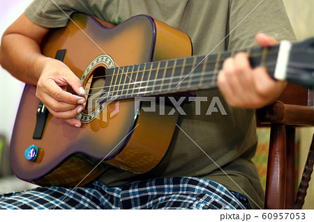 Hand  holding while playing acoustic guitar 60957053