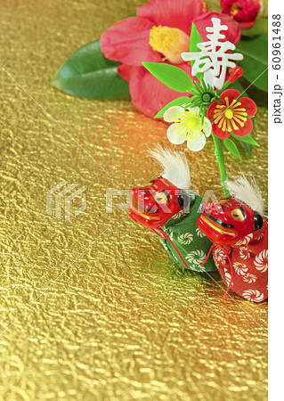 冬のバラとも呼ばれるツバキの花と金箔の紙の上に立つ２頭の獅子舞の可愛いフィギュアと壽の漢字の書いてあ 60961488