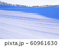 冬の北海道の美瑛の丘に朝日がさして丘のうねが筋模様になってる様子 60961630