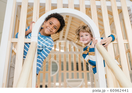 Cute cheerful preschoolers having fun on playground at children center 60962441