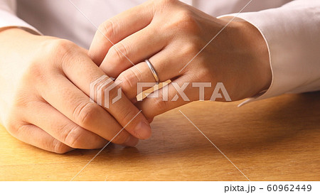 指輪を外す女性 60962449