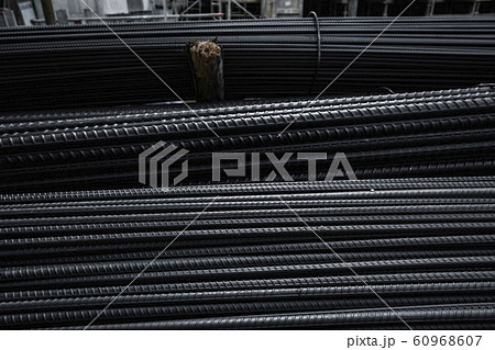 Building armature in the warehouse of metallurgical products or on construction site. Stack of heavy metal reinforcement bars with periodic profile texture. Steel construction armature. 60968607