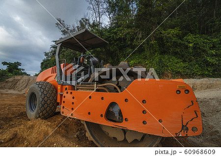 Soil compactor with vibratory padfoot drum. Heavy duty machinery working on highway construction site. Vehicle for soil compaction. Road construction equipment. Paving. Compaction of the road. 60968609
