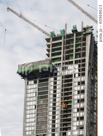 Construction site of building a high-rise building with a cranes against blue sky. Construction site of building a high-rise building with a cranes against blue sky. 60968623
